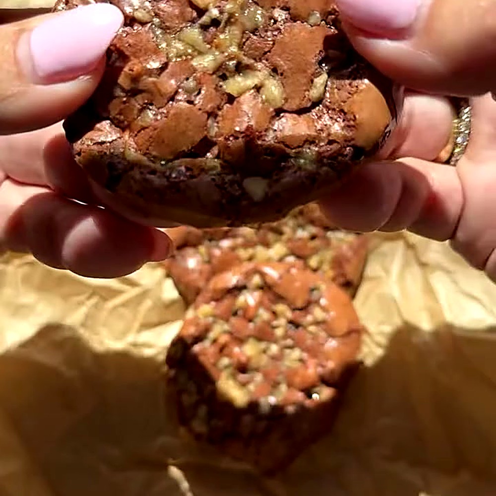 Gluten-free toffee brownie cookie broken open to show the fudgy center