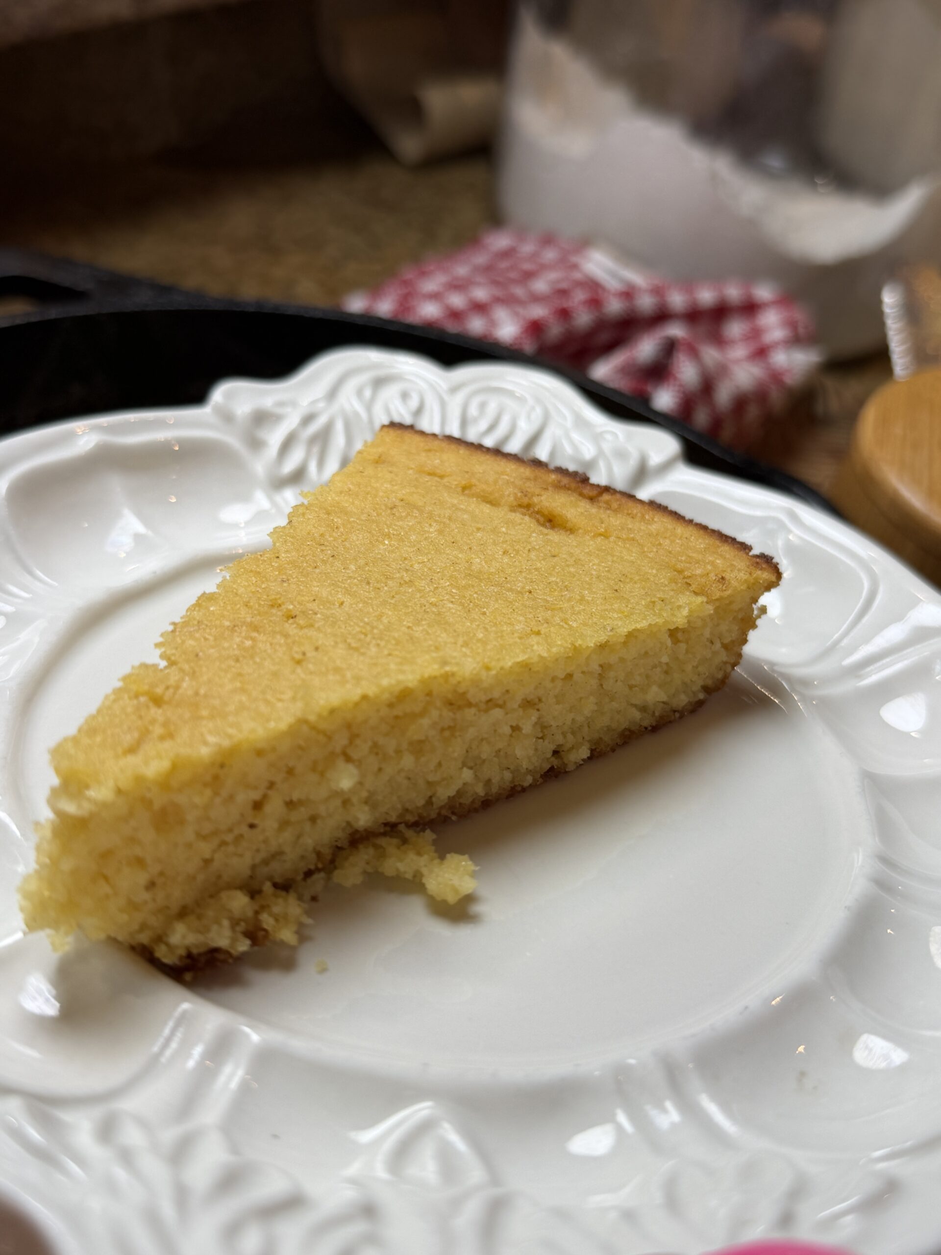 A slice of gluten-free brown butter cornbread on a white plate